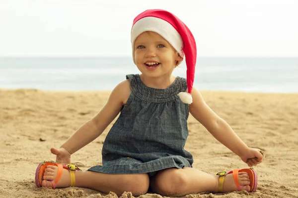 Cute girl in Santa hat having fun at the tropicals — Stock Photo, Image