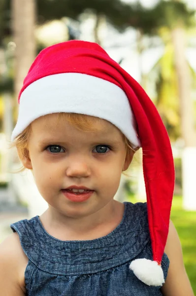 Cute girl in Santa hat having fun at the tropicals — Stock Photo, Image