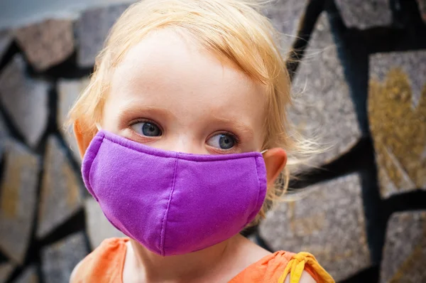 Cute little girl in bright face mask — Stock Photo, Image