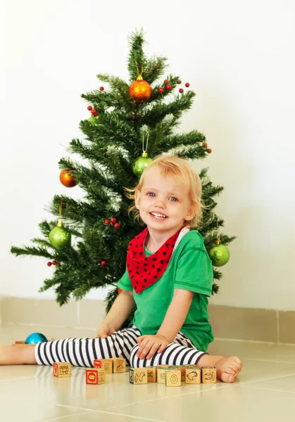 Kis lány pózol a karácsonyfa közelében — Stock Fotó