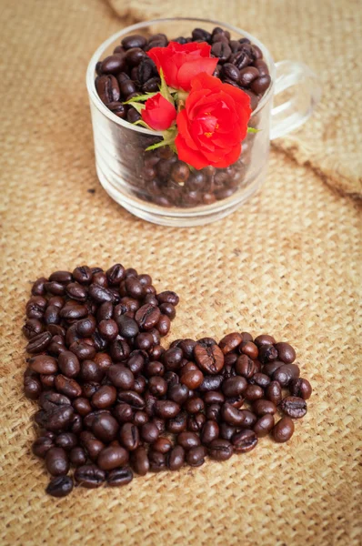 Herz mit gerösteten Kaffeebohnen auf dem Hintergrund — Stockfoto