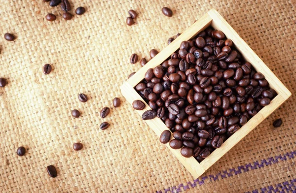 Box with roasted coffee beans on the burlap background — Stock Photo, Image