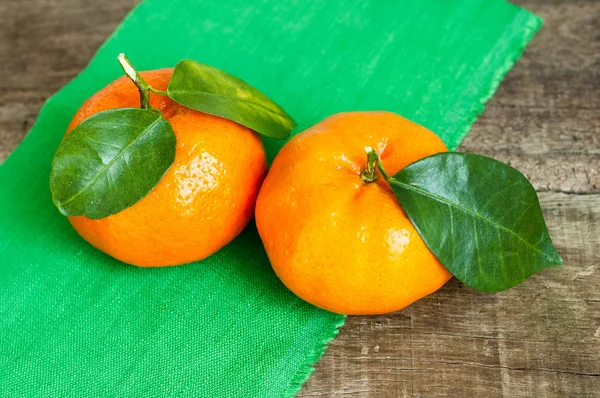 Tangerines avec feuilles sur une table en bois — Photo