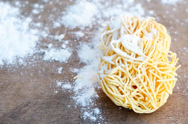 Fresh pasta nests on wooden table — Stock Photo, Image