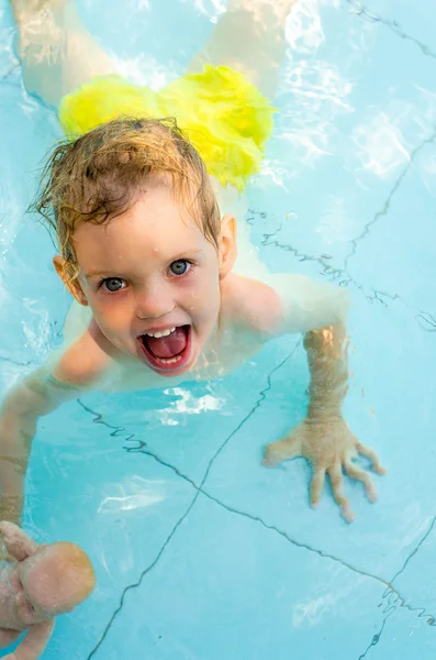 Cheerful kid in the swimming pool water — Stock Photo, Image
