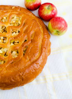 golden crispy apple pie on white fabric