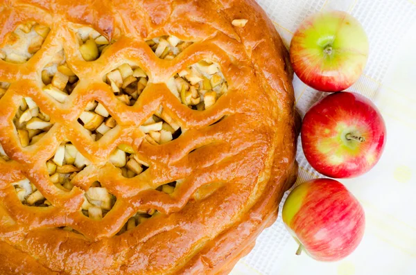 golden crispy apple pie on white fabric