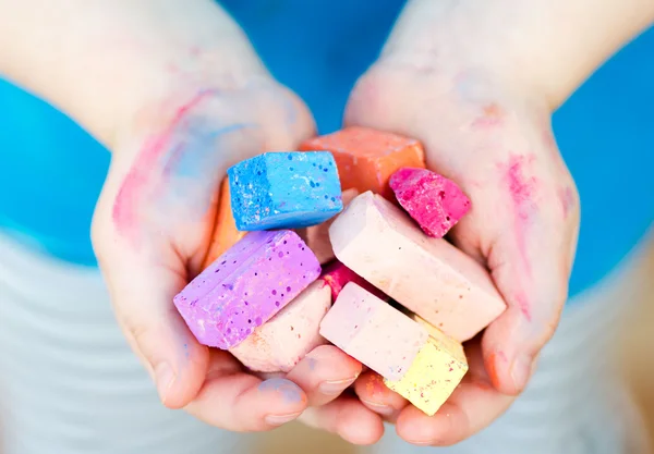 Child's hands holding  colored chalk pieces — Stock Photo, Image