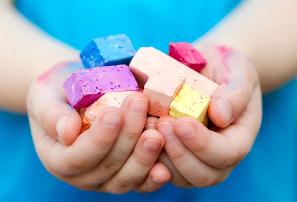 Child's hands holding colored chalk pieces — Stock Photo, Image