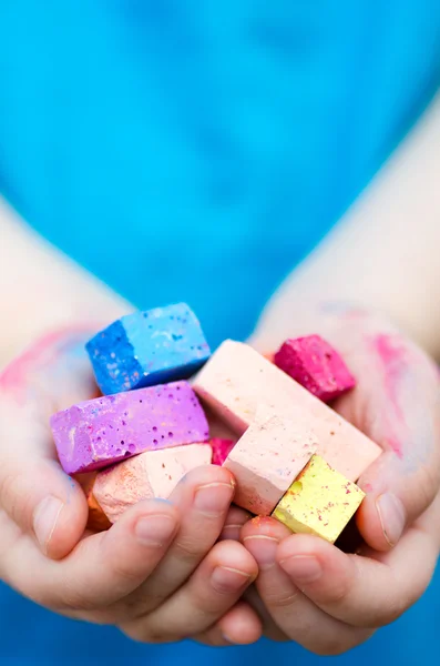 Child's hands holding colored chalk pieces — Stock Photo, Image