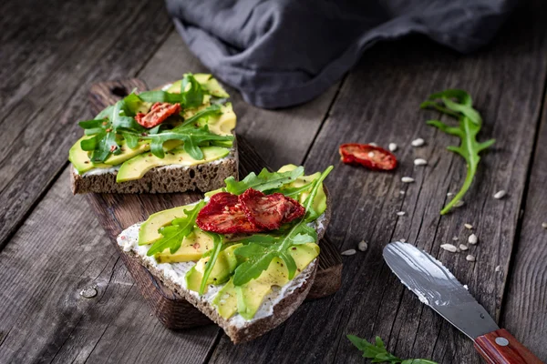 Torrada saudável com abacate, queijo branco e rúcula — Fotografia de Stock