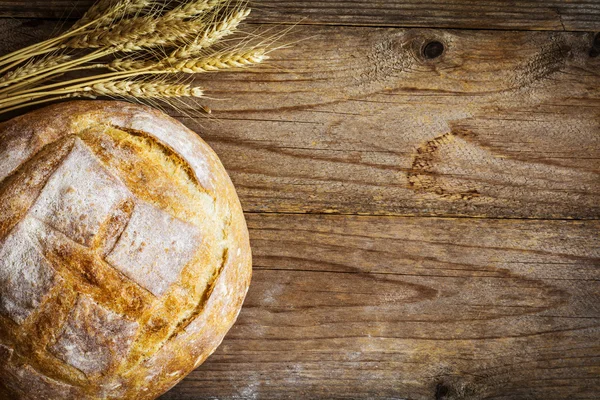 Vaření pozadí: bochník chleba a pšenice golden uši — Stock fotografie