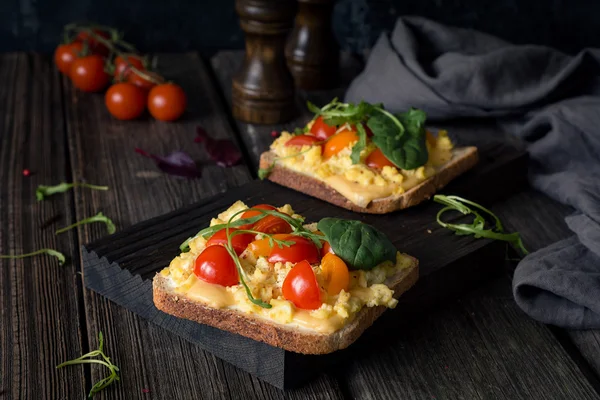 Torrada com ovos mexidos, queijo, tomate e salada verde — Fotografia de Stock