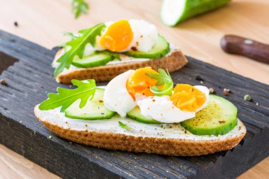 Ahşap kesme tahtası salatalık ve yumurta tost