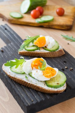 Ahşap kesme tahtası salatalık ve yumurta tost