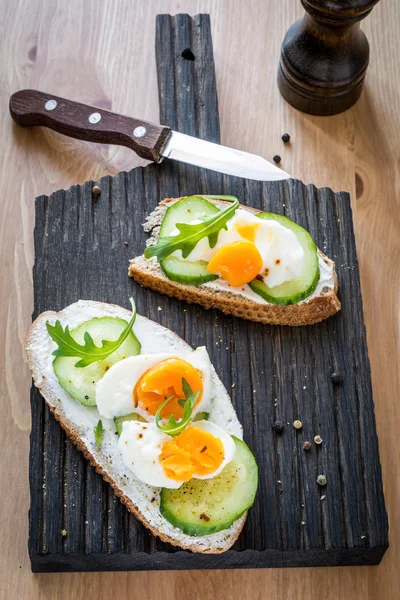 Cucumber and egg toast on wooden cutting board — Stock Photo, Image