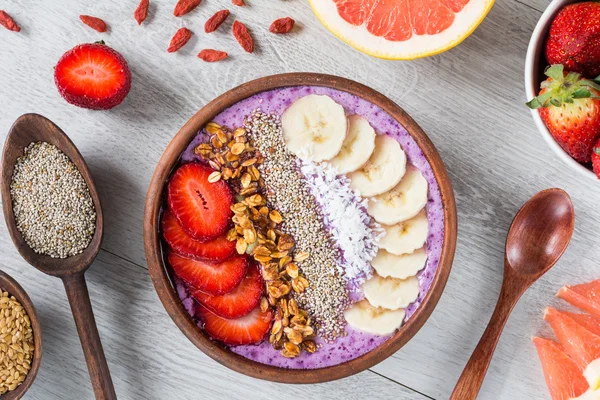 Tazón de batido con frutas y varios súper alimentos en la mesa. Desayuno saludable — Foto de Stock