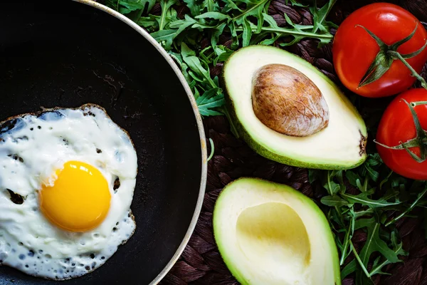 Завтрак: яичница, авокадо, помидоры и зеленый салат — стоковое фото