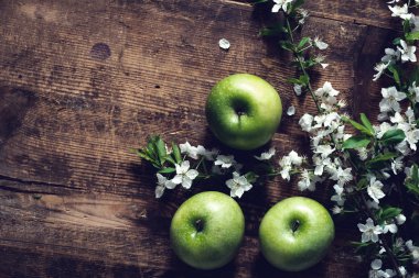 Yeşil elma ve kiraz çiçekleri ahşap zemin, yaz arka plan üzerinde