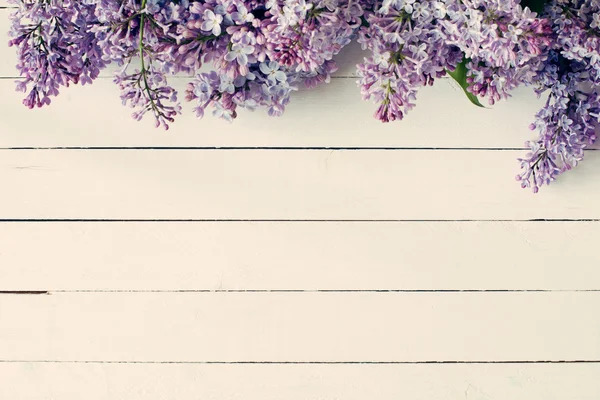 Fond en bois vintage avec des fleurs lilas / violettes sur le dessus . — Photo