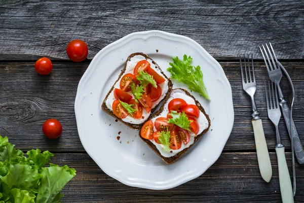 Toast sandwiches with fresh cheese, chopped tomatoes and green salad