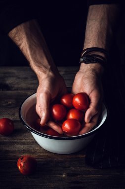 Domates yıkama. Erkek Şef çamaşır domates. Domates elinde