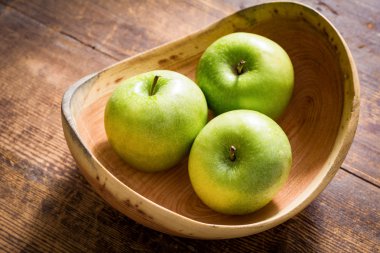 Ahşap kase üç yeşil elma