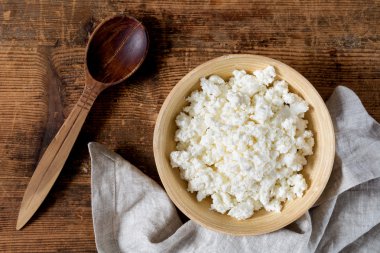 Süzme peynir, masa örtüsü ve tahta kaşık rustik ahşap masa üzerinde. Üstten Görünüm