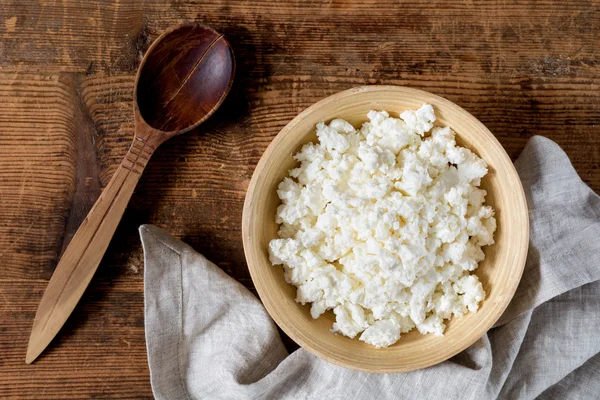 Süzme peynir, masa örtüsü ve tahta kaşık rustik ahşap masa üzerinde. Üstten Görünüm