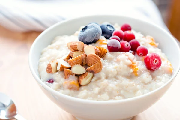 Oatmeal porridge bowl with berries and nuts — Stock Photo, Image