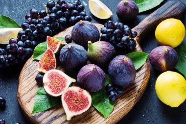 Meyve tabağı: taze incir, siyah üzüm ve limon 