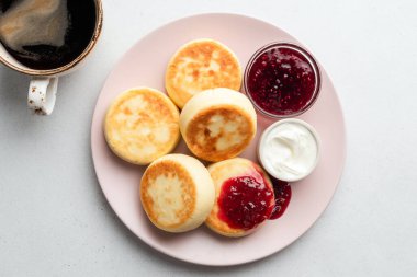 Tabakta ahududu reçeli süzme peynirli börek, üst manzara. Syrniki. Rus, Ukrayna mutfağı yemekleri