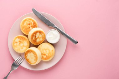 Pembe arka planda izole edilmiş ekşi kremalı süzme peynirli börek ya da şuruplu şurup.