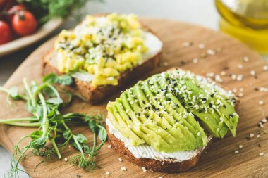 Tahtada susam tohumlu avokado tostu. Sağlıklı aperatif, aperatif veya avokado dilimli kahvaltı.