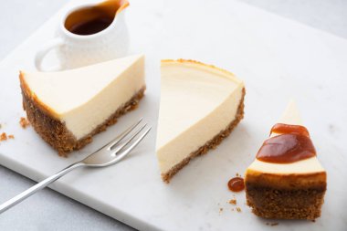 Mermer tahtada karamel soslu üç dilim cheesecake. Lezzetli klasik New York usulü cheesecake