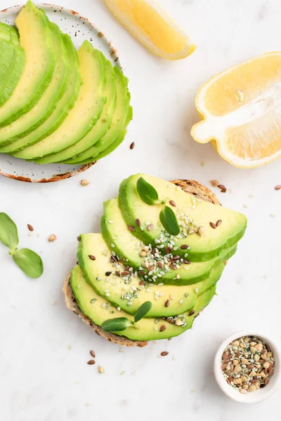 Tostadas de aguacate sobre mesa de mármol blanco — Foto de Stock