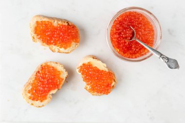 Baget ekmeğine kırmızı havyar ve tereyağı.