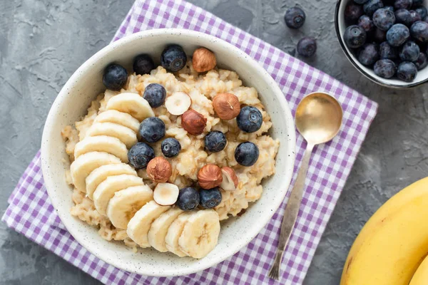 Oatmeal porridge with blueberry, banana and hazelnut — Stock Photo, Image