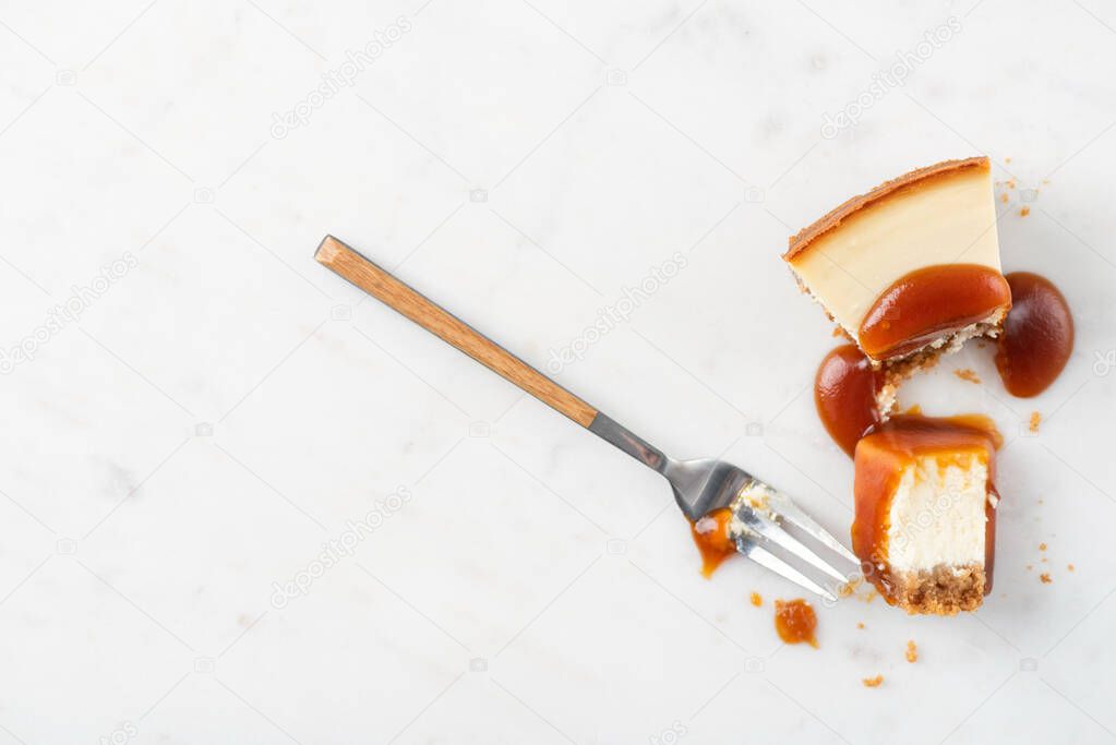 Broked slice of cheesecake with caramel sauce. Eating cheesecake process