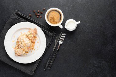 Siyah arka planda kahve ve kruvasan.