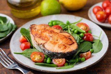 Kızarmış somon bifteği, ıspanak ve vişneli domates.