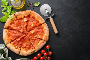 Siyah Beton Arkaplanda Sıcak Pepperoni Pizzası Pizza Kesicisi, Basil Leaf ve yanında vişneli Domatesler. Üst Manzara. Delivious Pizza, Metin Menüsü veya Tasarımı için Boşluğu Kopyala
