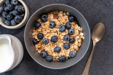 Üzerinde yabanmersini resmi olan bir kase müsli. Sağlıklı kahvaltı gevrekleri