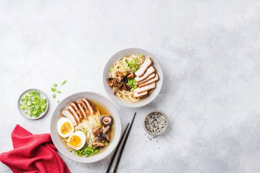 Tavuklu ramen eriştesi gri beton arka planda bir kasede. Masa üstü görünümü. Asya mutfağı