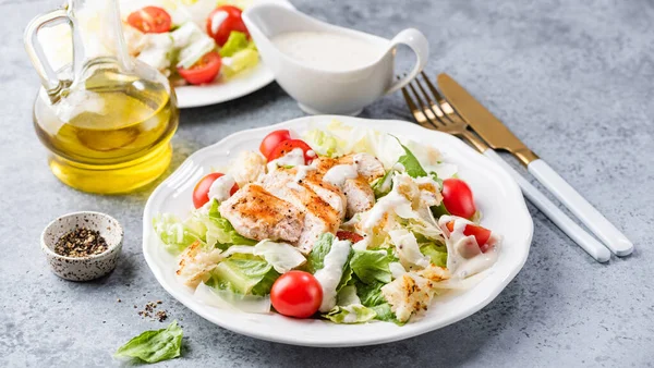 Salad with grilled chicken and cherry tomatoes Caesar. Popular famous in restaurants Caesar salad with dressing sauce