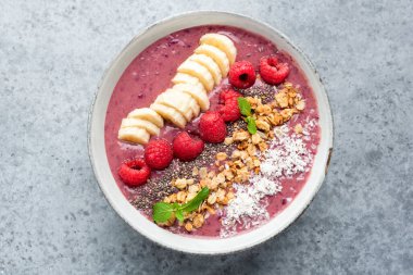 Sağlıklı pembe ahududu smoothie. Beton arka planda izole edilmiş çeşitli abur cubur malzemeleri var.