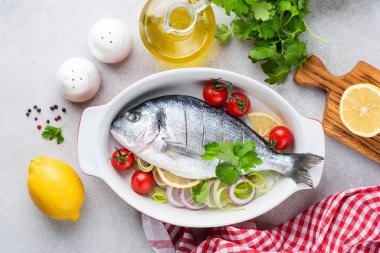 Dorado ve sebzeleri seramik tabakta pişirmeye hazır. Üst Manzara. Sağlıklı yemek pişirmek.