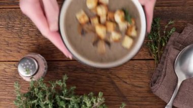 Mantar kremalı çorba, kıtır ekmek ve kekik. Sağlıklı çorba, ahşap masa arkaplanı.