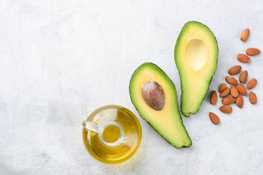 Avokado, badem ve zeytinyağı. E vitamini ve kozmetik ürünleri açısından sağlıklı yağ ürünleri açısından zengin, üst görünüm, kopyalama alanı