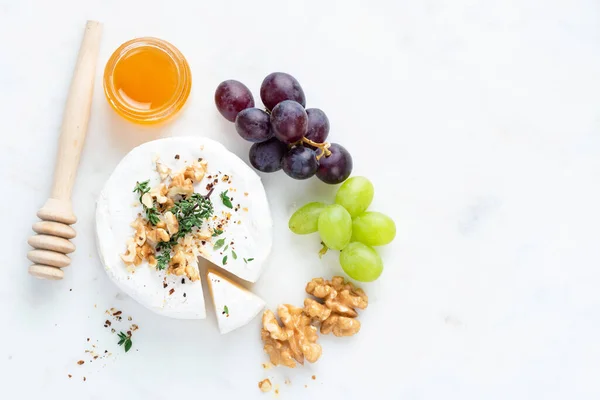 Queijo Brie ou camembert servido com uvas, mel e nozes — Fotografia de Stock